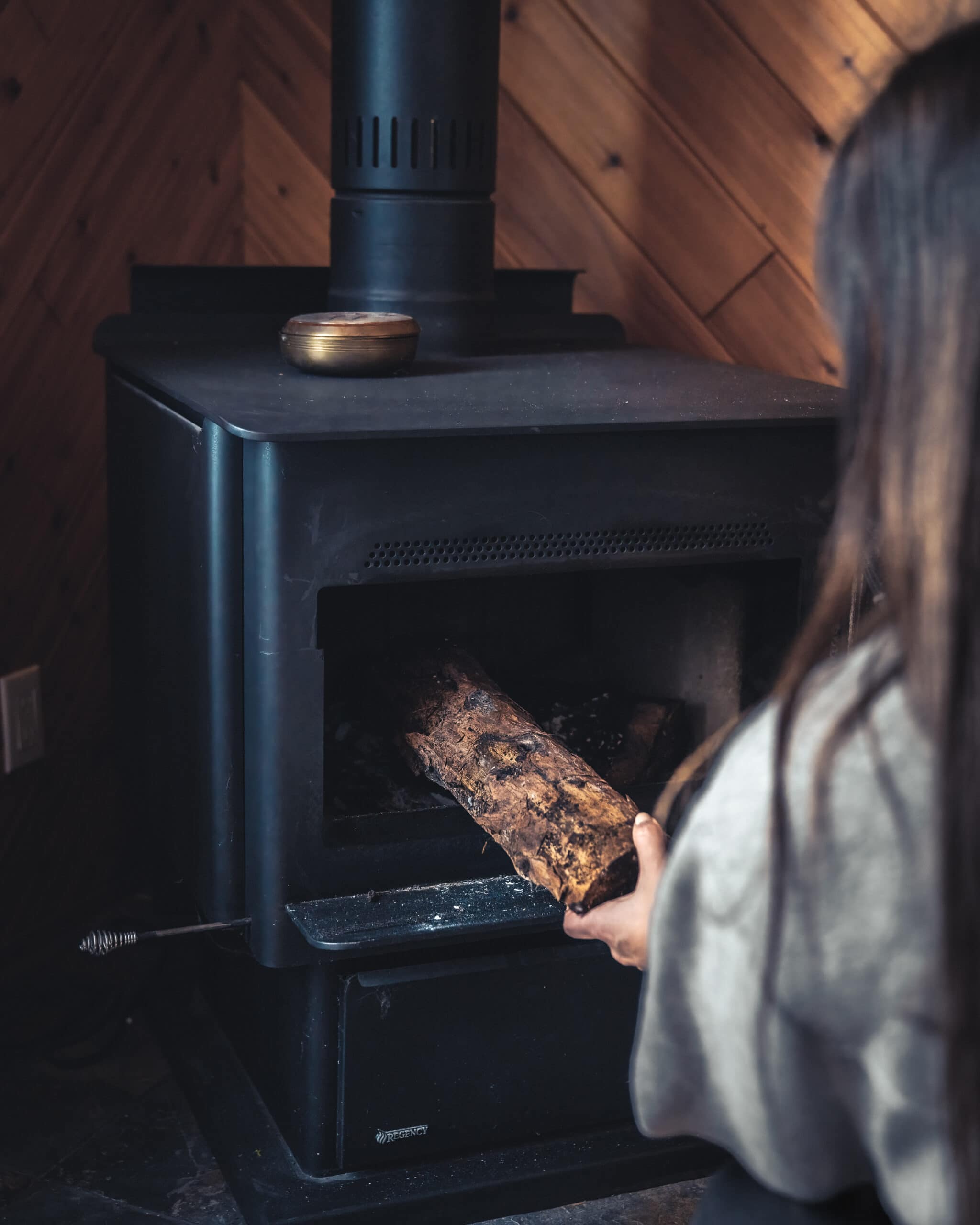 cabin rental Gimli Manitoba adding wood to woodstove